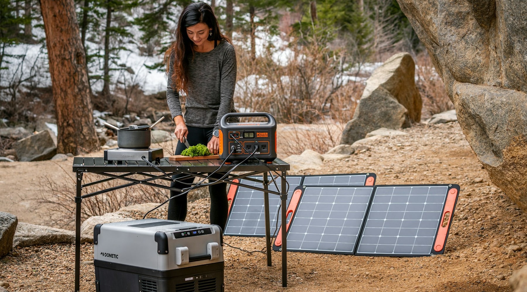 A lady powering a fridge with a portable power station and solar panels