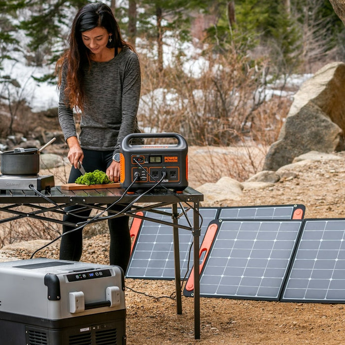 A lady powering a fridge with a portable power station and solar panels