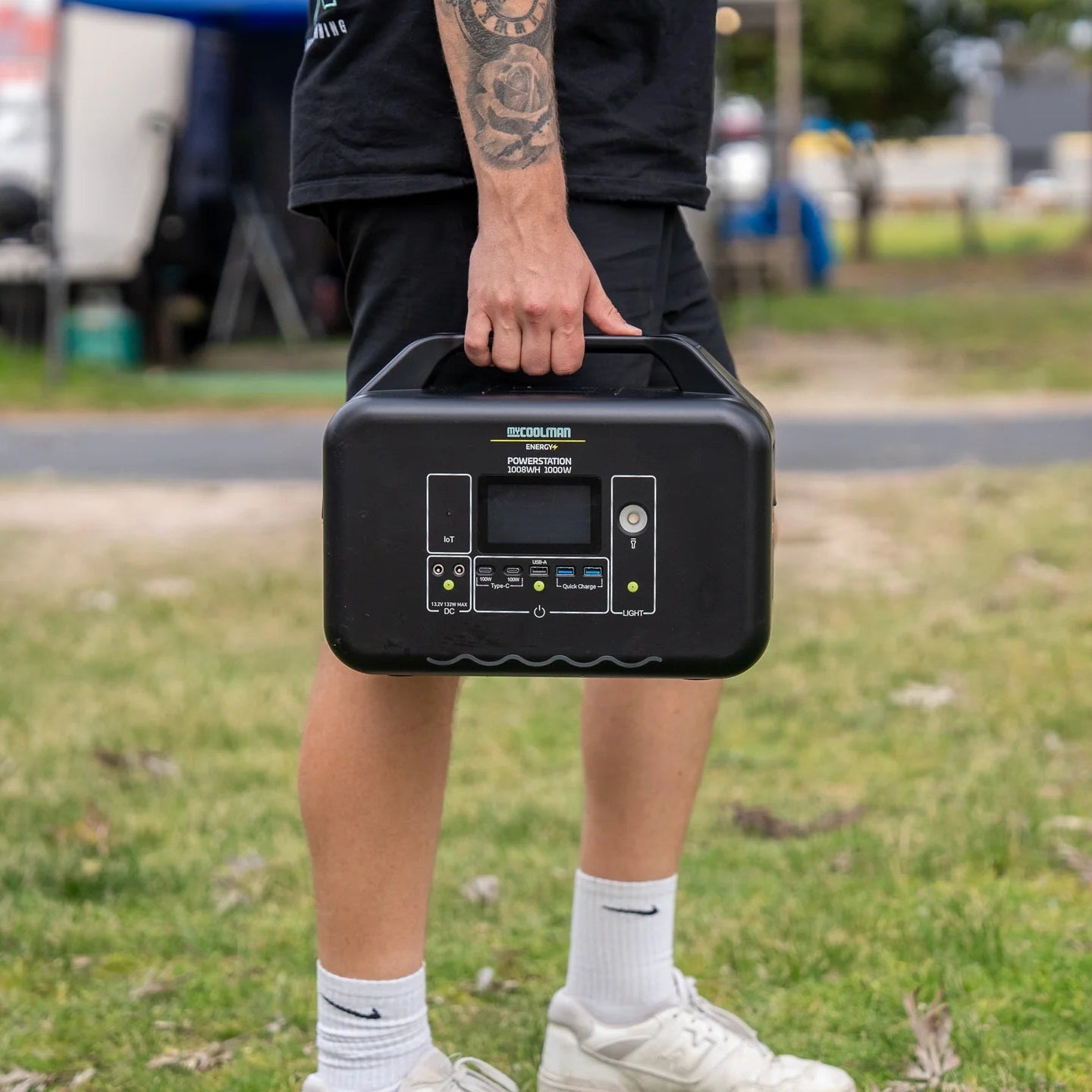 A photo of a man holding a MyCOOLMAN 1000W 78Ah Portable Power Station.