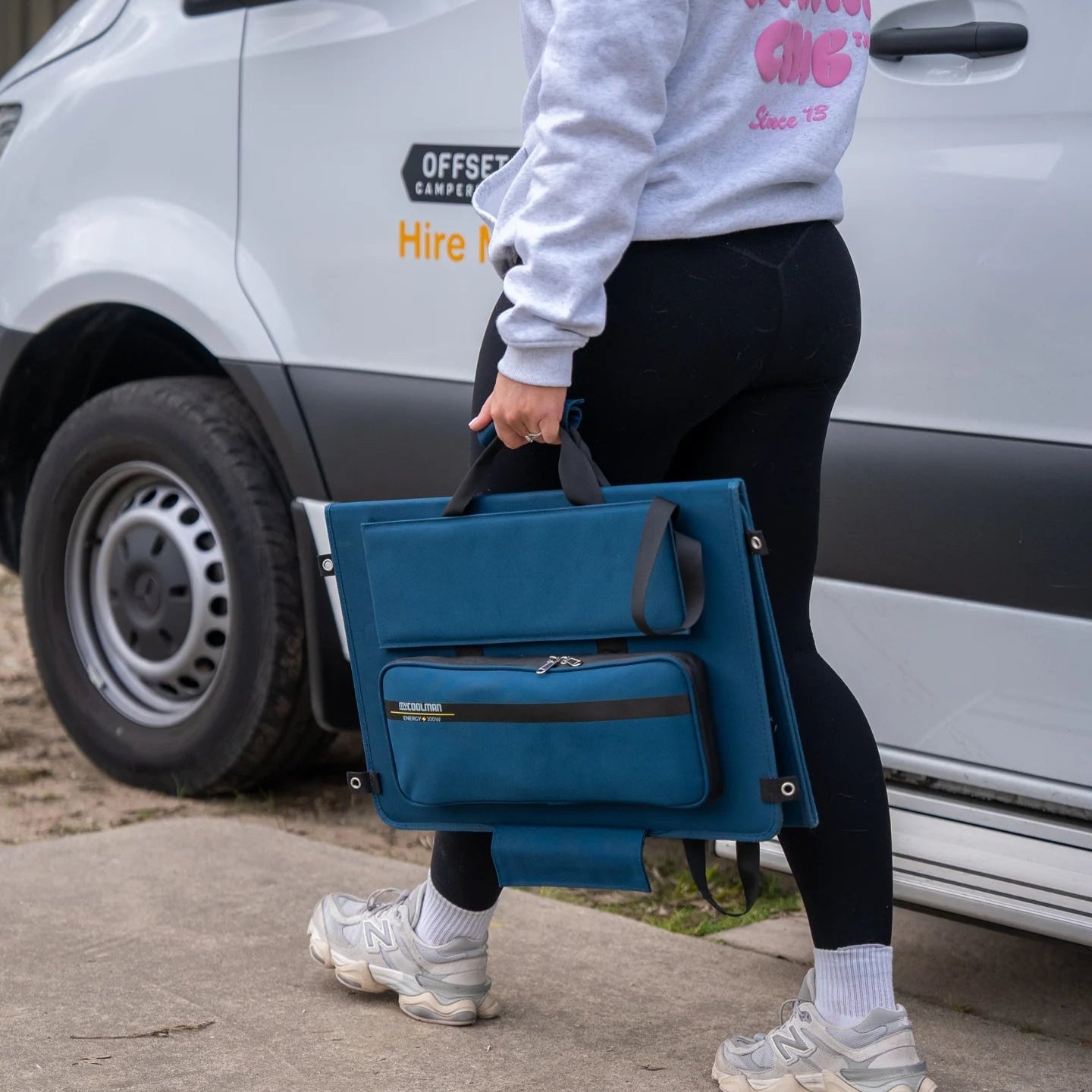 A photo of a woman holding a MyCOOLMAN 100W Flexible Solar Blanket