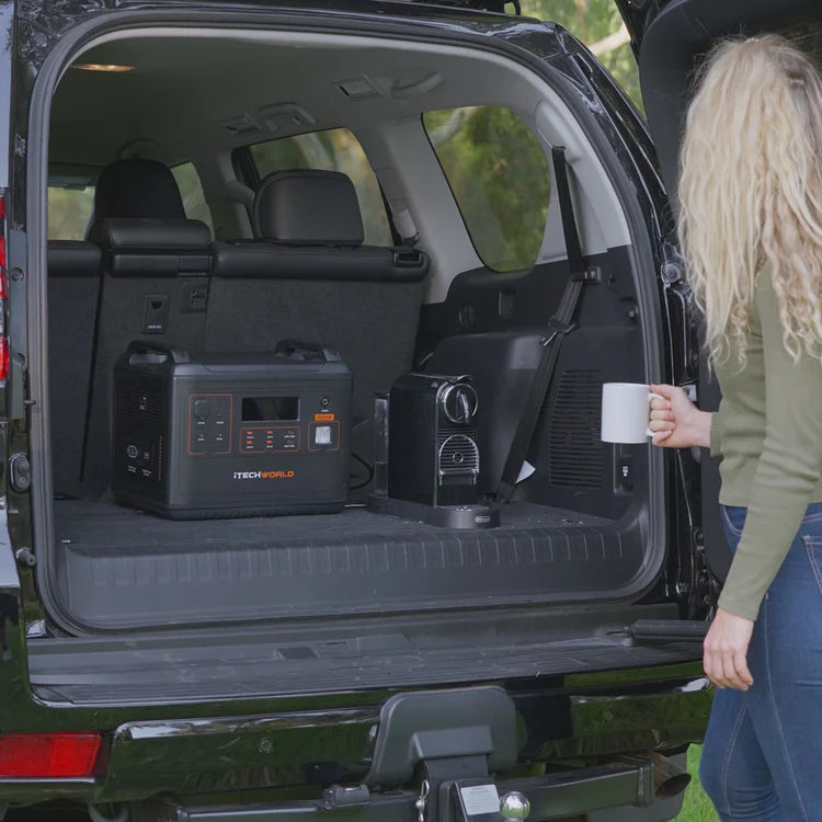 A photo of a black iTechWorld PS2000 Power Station in the back of a car plugged into a coffee machine