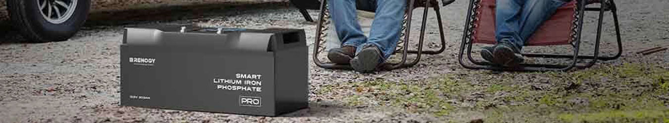 A Renogy 24V Lithium Battery in front of 2 campers
