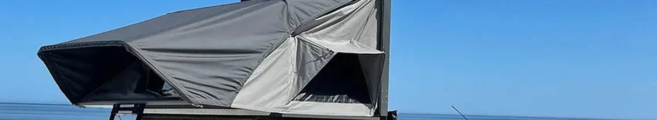 A hard shell roof top tent sitting on top of a 4wd.