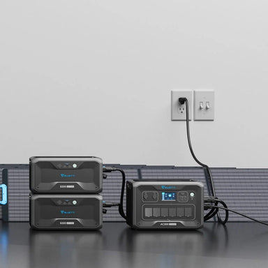 A photo of a Bluetti AC300 3000W Portable Power Station charging next to two bluetti B300K expansion batteries.