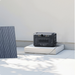A photo of a Bluetti Apex 300 backup battery for home plugged into a solar panel outdoors.