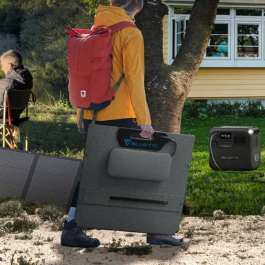 A photo of a Bluetti PV200 200W solar blanket being held by a person whilst walking outdoors.