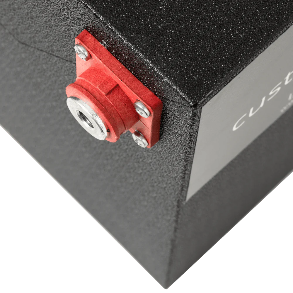 A photo of a black custom lithium 560ah 12v lithium battery showing the red terminal connection.