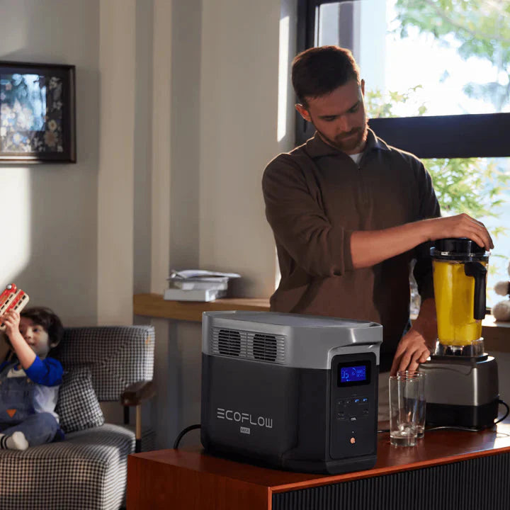 A photo of an EcoFlow Delta 2 Max Portable Power Station plugged into a blender with a man using the blender.