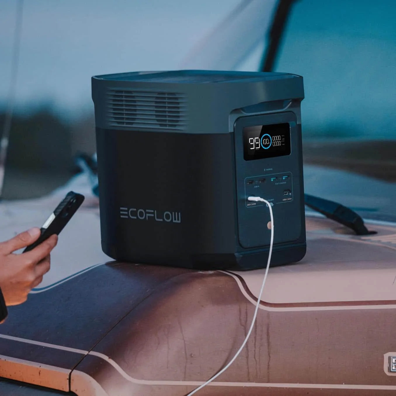 A photo of an EcoFlow Delta 2 Portable Power Station with a phone plugged into it.