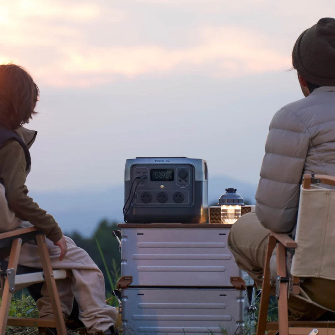 A photo of two people sitting outside with an EcoFlow River 2 Pro Portable Power Station connected to a small light.