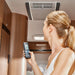 A photo of a lady holding a remote to control her Truma Aventa Comfort Roof Mounted Air Conditioner.