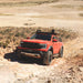A Ford Ranger Raptor driving on a rocky off-road track in the Australian bush.