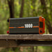 A photo of an iTechWorld 1000W power inverter sitting outdoors on top of a bench.