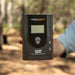 Black iTechWorld 40A MPPT solar charge controller with digital display being held by a man outdoors.