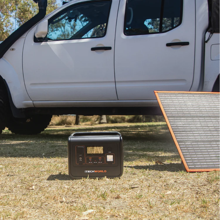 Outdoor photo of a Black iTechWorld PS800 Portable Power Station next to a solar panel.