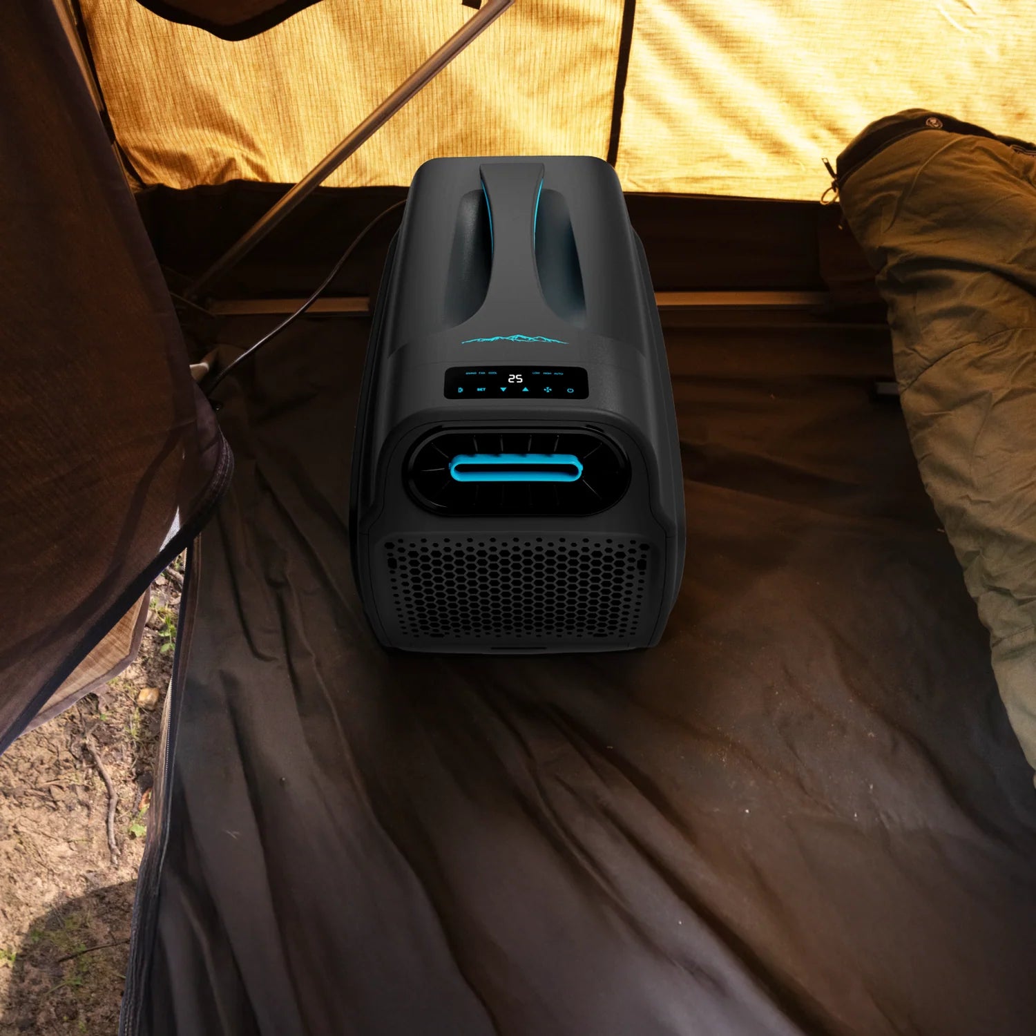 A photo of a black and blue iTechWorld iFrost portable 1000W air conditioner inside of a camping tent.