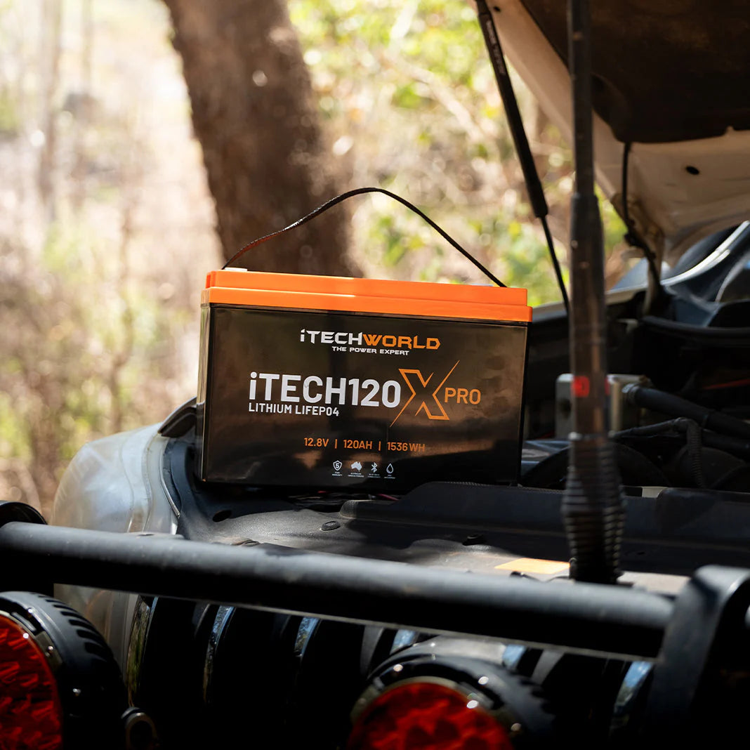 A photo of an iTechWorld 120xPro Lithium Battery sitting on top of a car with its hood up.