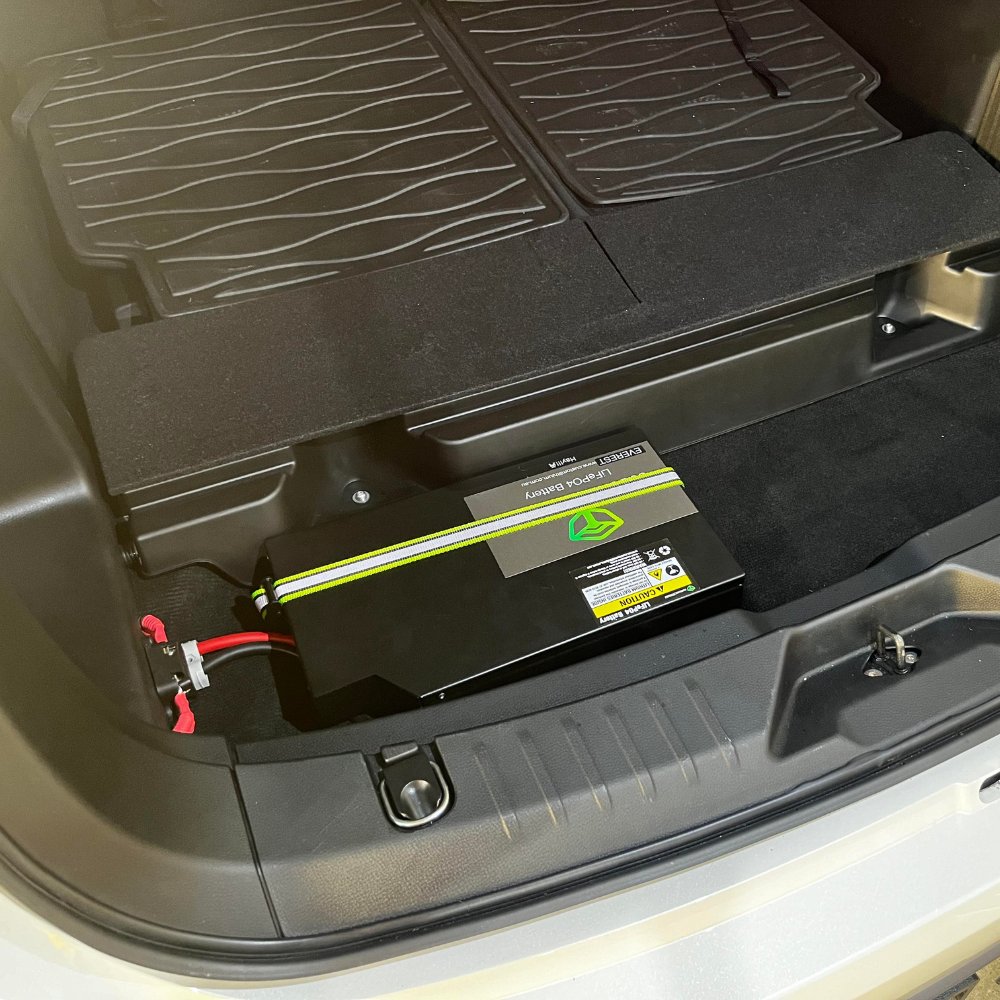 Custom Lithium dual battery installed under the rear floor of an Isuzu MU-X with the cargo liner lifted and the battery terminals connected.